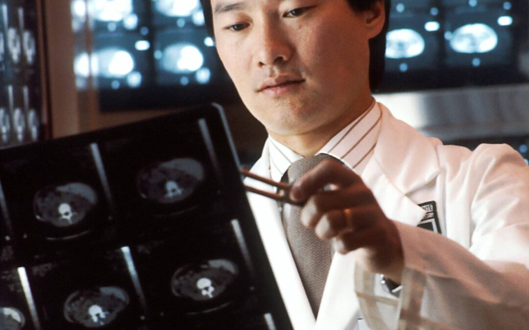 A male Asian radiologist looking at computed tomography (CT) scans.