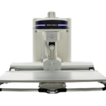 Front view of a large medical imaging machine with a patient table and overhead gantry ready for scans in a clinical setting (amrad medical).