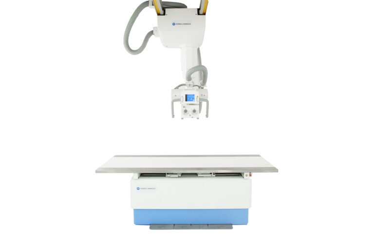 Konica minolta medical x-ray machine with an overhead gantry and a flat examination table against a white background.