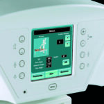 Teal touchscreen on a medical scanner showing the word skull and skull-position data with numeric readouts and control buttons on the side.