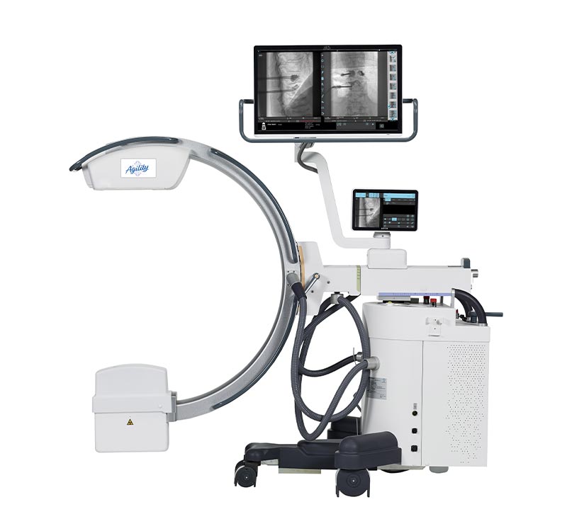 C-arm fluoroscopy machine on a wheeled base with two screens displaying x-ray images of the chest and spine.