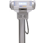 Vertical medical imaging stand with a control console and amrad medical branding, mounted on a tall column with a base rail system.