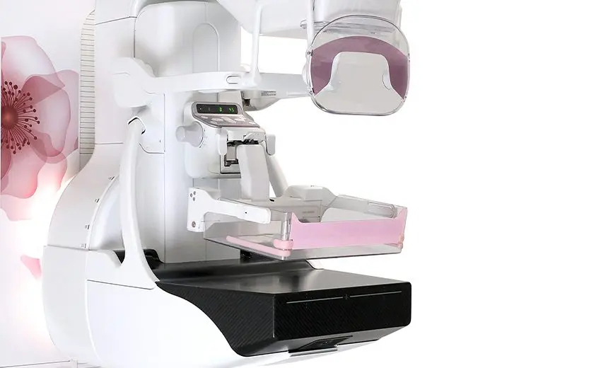 Dental panoramic dental x-ray machine with a pink bite block and floral wall in the background, ready for imaging.