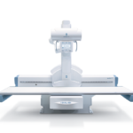 Radiography table with a vertical imaging gantry and control panel for x-ray exams.