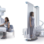 Patient seated at a ct scanner on the left and a standing imaging system with a patient on the right in a clinical room.