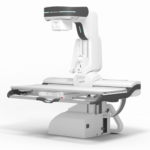 White radiotherapy linear accelerator with a movable patient table and robotic gantry, shown in a clinical setup for cancer treatment