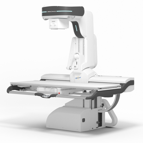 White radiotherapy linear accelerator with a movable patient table and robotic gantry, shown in a clinical setup for cancer treatment