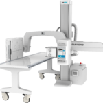 Industrial medical x-ray imaging system with a long patient table and a tall vertical gantry labeled drgem, on wheels for mobility.