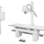 Medical x-ray imaging table with ceiling-mounted radiography unit and control console for diagnostics? Oriented for x-ray exams.