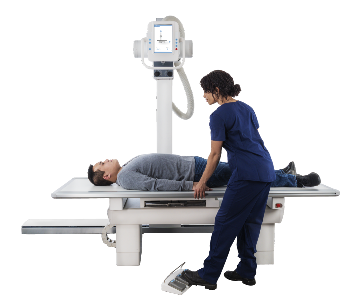 Patient lies on an x-ray table as a clinician in blue scrubs positions a tall imaging unit with a monitor above them.