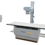Medical x-ray imaging table with vertical imaging stand and control console; amrad medical branding visible on the unit