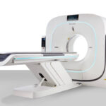 Medical ct scanner with a wide circular gantry and a sliding patient table in a clinical setting.