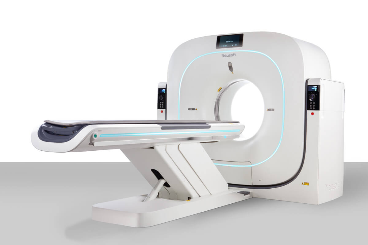 Medical ct scanner with a wide circular gantry and a sliding patient table in a clinical setting.