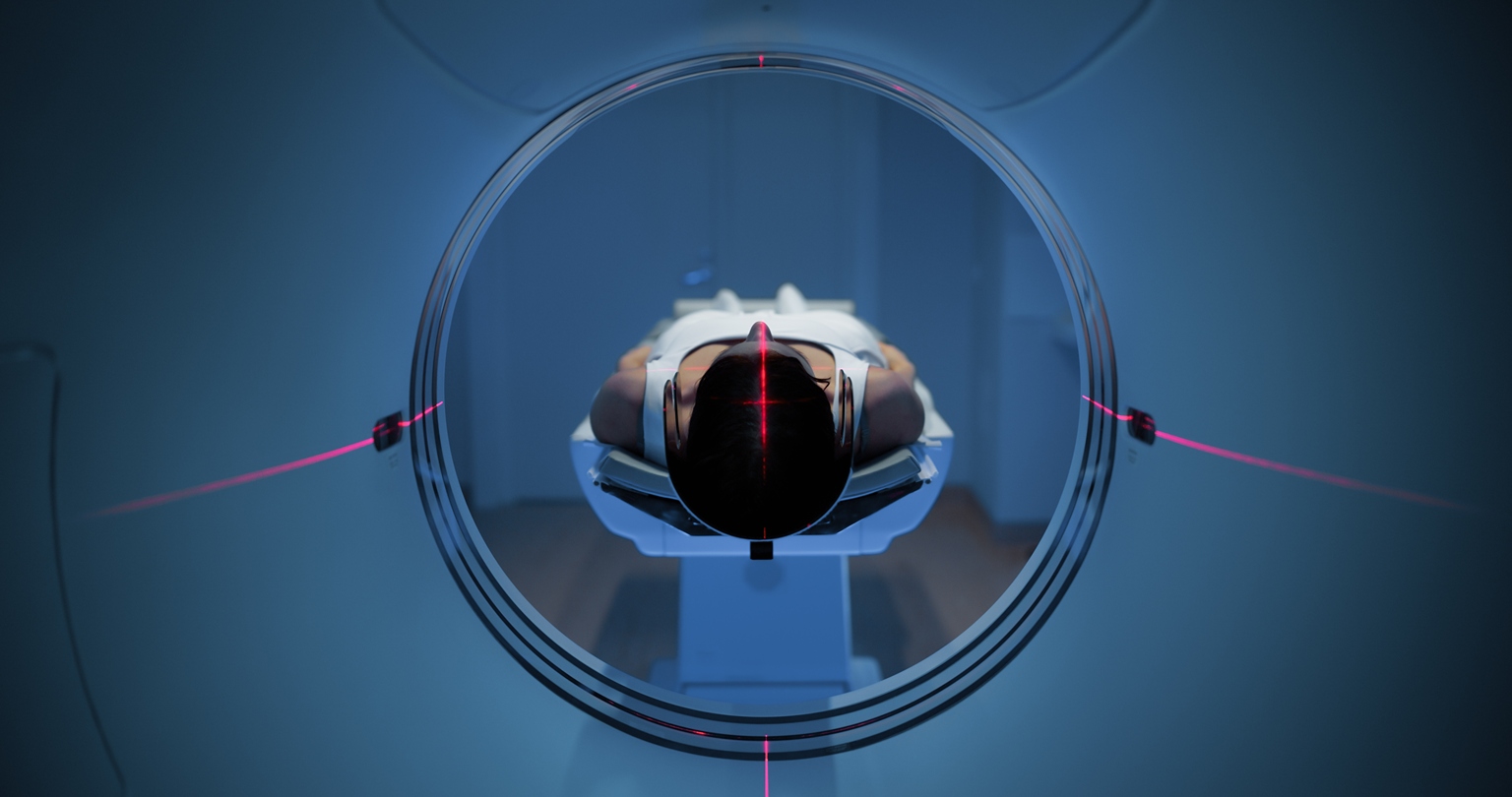 Interior-machine-pov-final - Imperial Imaging Technology Person lying on an mri scanner bed inside a circular bore with red alignment lasers visible