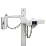 Vertical medical imaging stand with articulated arms and a control panel, including a side monitor displaying radiographs