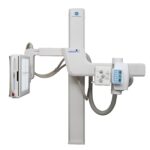 Medical x-ray imaging system with a vertical column and blue konica minolta logo, shown in a cross-table setup.