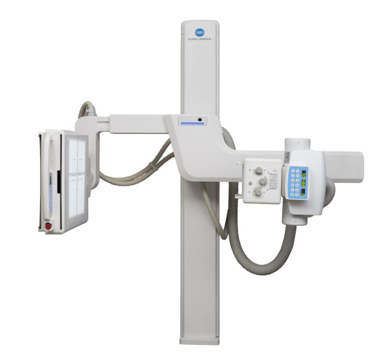 Medical x-ray imaging system with a vertical column and blue konica minolta logo, shown in a cross-table setup.