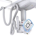 Close-up of a medical imaging device with several flexible silver hoses connected to a stand or arm attachment.