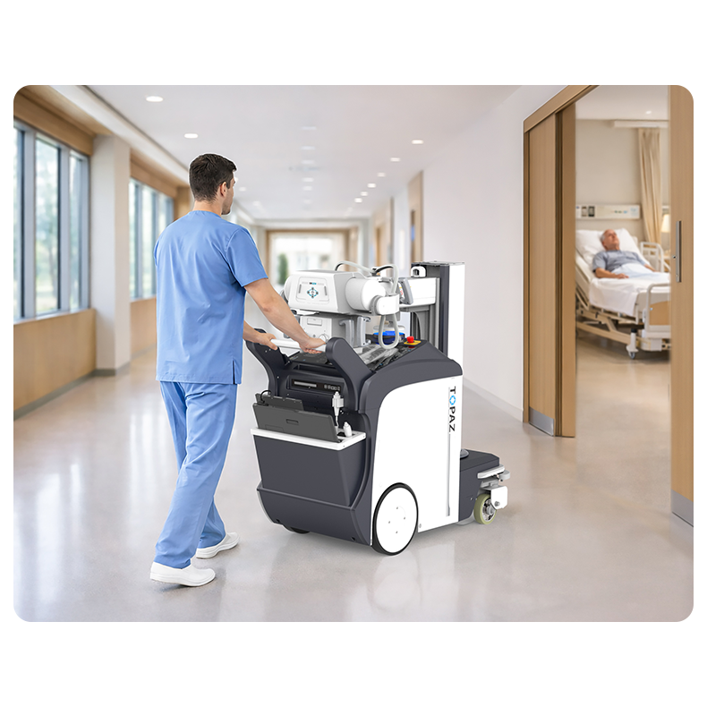 Healthcare worker in blue scrubs operates a wheeled portable medical device in a bright hospital hallway toward patient rooms. 2024 model included. (informative) - concise alt text for screen readers.