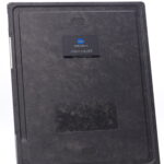Back view of a dark aerodr device with a blue konica minolta badge and textured surface.