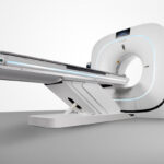 Ct scanner with sliding patient table extending toward the circular gantry in a clean medical setting