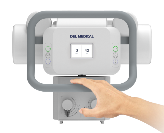 Front view of a del medical medical device with a central touchscreen showing 0 and 40, and a hand turning a dial on the lower panel within a gray frame