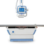 Medical x-ray radiography table with an overhead display monitor mounted above for diagnostic imaging.