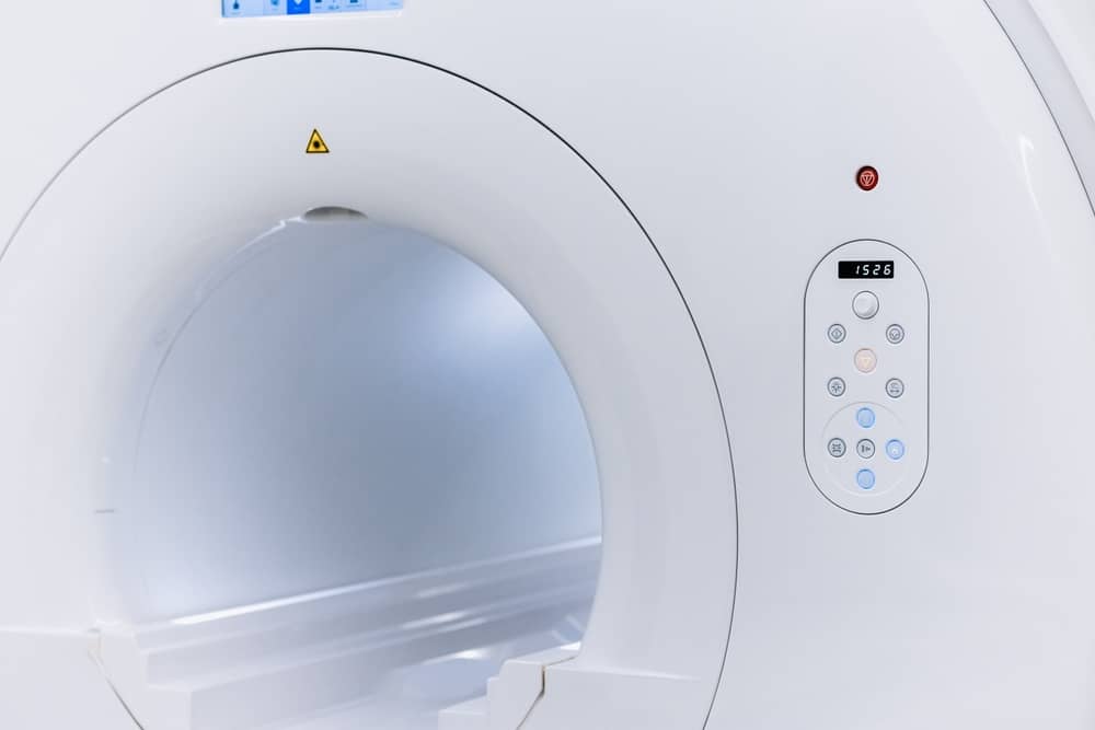 Mri scanner with a circular opening and a side control panel of buttons and display