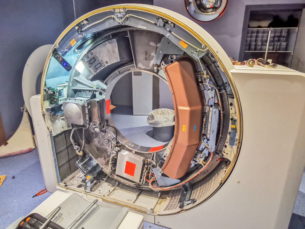 Repair of a Ct Scan or Tomography Scanner with Complete Clinical Capabilities A scanning machine with the side panel removed exposing the mechanical components inside.