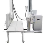 Radiographic imaging system with a flat patient table and two vertical columns on rolling bases, control panel at side (amrad medical).