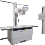 Medical x-ray imaging system on a stand with a horizontal table and a control console labeled amrad medical.