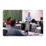 Instructor presenting to clinicians in a radiology training room, with brain mri images on monitors.