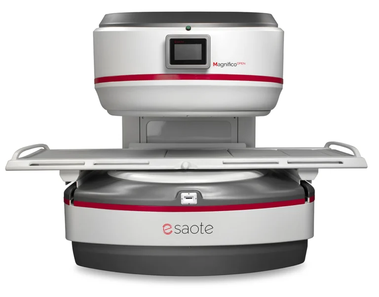 Open mri scanner (magnifico open by saote) with the patient table extended, ready for imaging in a white-gray unit with red accent stripe.