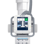 Front view of a del medical ventilator with a color touch screen and flexible breathing tubes connected to the unit, mounted within a frame.
