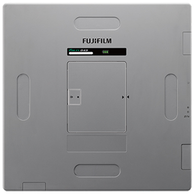 Back panel of a fujifilm device featuring a central battery/card compartment door and a small status display above it. Two vertical grip recesses are visible on the sides.